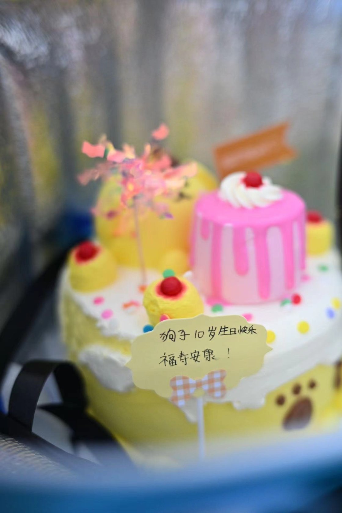 写有生日祝福的粉色和黄色生日蛋糕